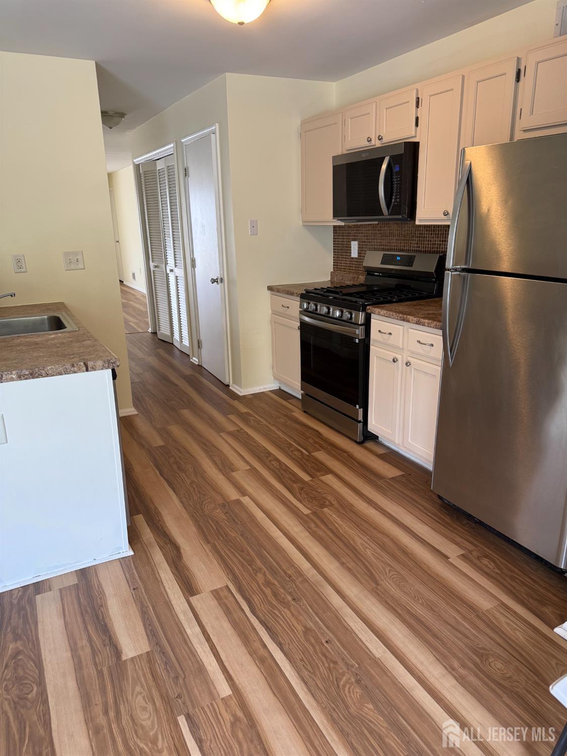 813 Plymouth Road North Brunswick, NJ 08902 - Photo 6 of 14 a kitchen with a refrigerator and a stove top oven