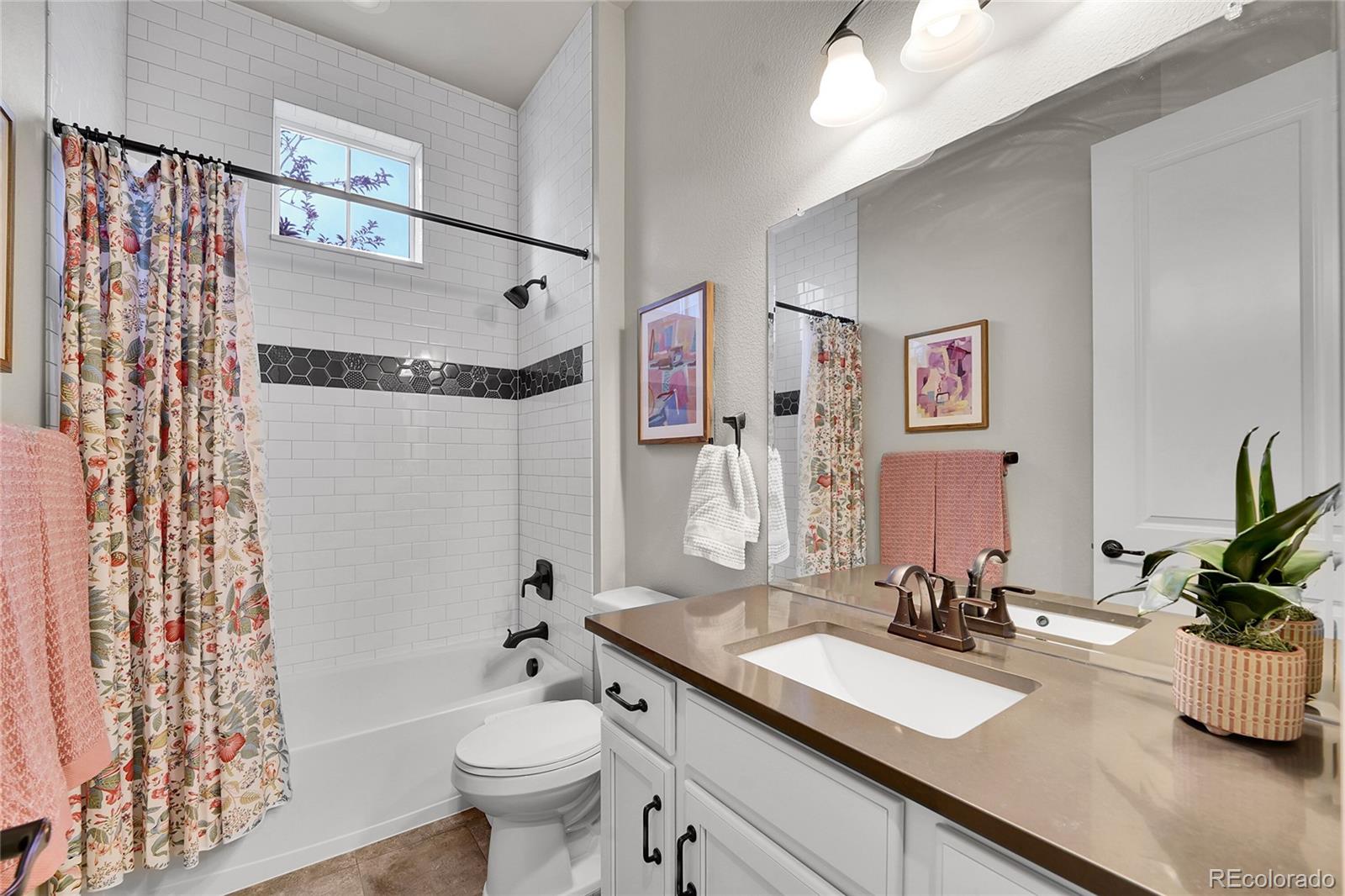 3429 Goodyear Street Castle Rock, CO 80109 - Photo 19 of 32 a bathroom with a granite countertop sink mirror vanity and toilet