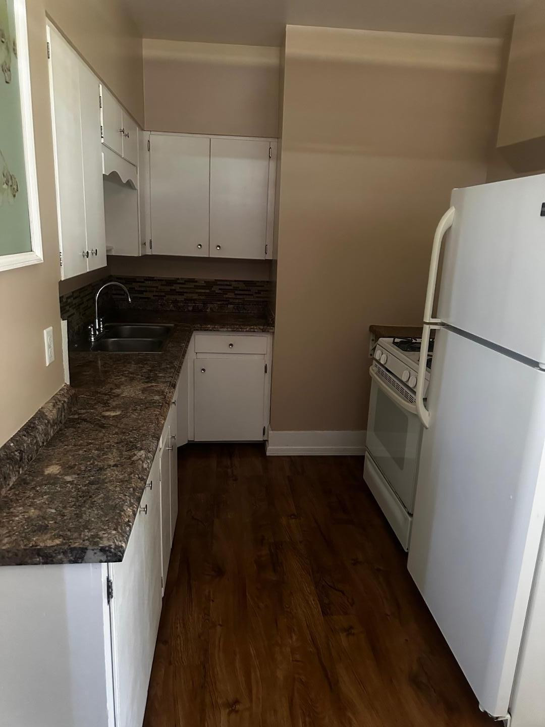 703 East 13th Street Douglas, AZ 85607 - Photo 5 of 16 a kitchen with a refrigerator a stove and white cabinets