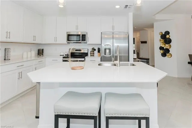 a kitchen with stainless steel appliances a refrigerator sink microwave and cabinets