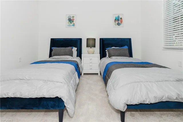 a spacious bedroom with two bed and a window