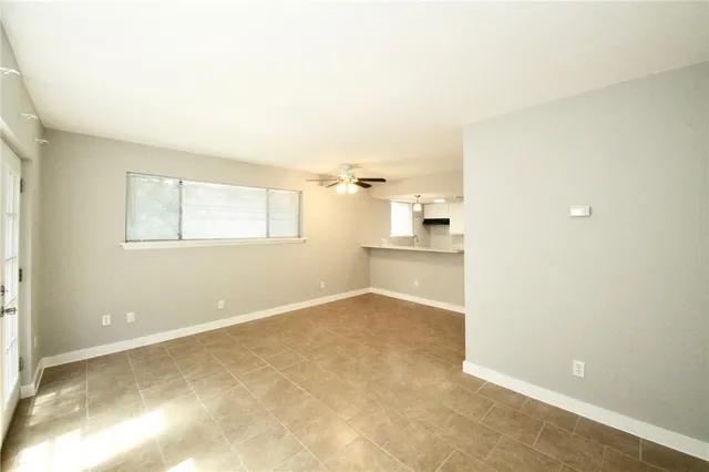 an empty room with cabinet and windows