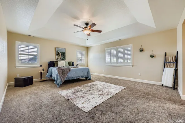 a spacious bedroom with a bed a couch and a window
