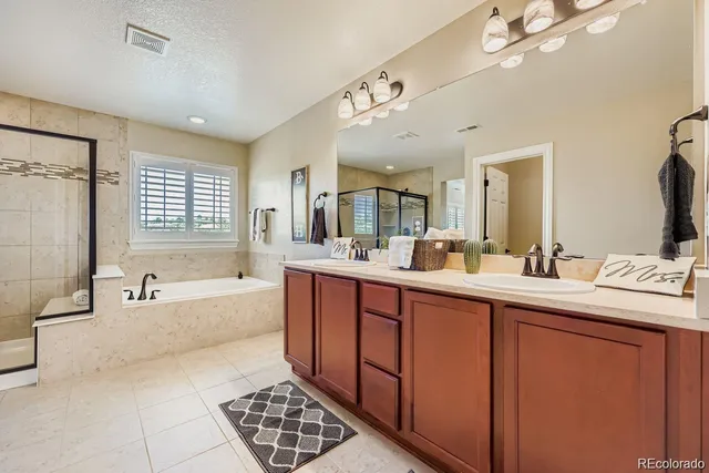 a spacious bathroom with a tub sink and mirror