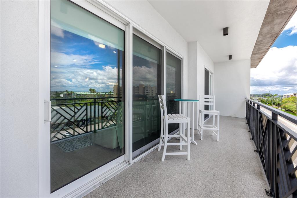 300 150th Avenue, Unit 502 Madeira Beach, FL 33708 - Photo 20 of 52 a view of a balcony with chair and floor to ceiling window
