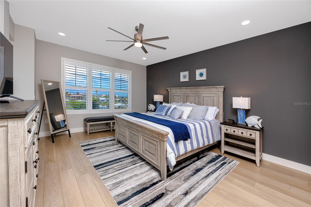 300 150th Avenue, Unit 502 Madeira Beach, FL 33708 - Photo 24 of 52 a bedroom with a bed and a chandelier