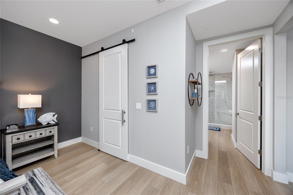 300 150th Avenue, Unit 502 Madeira Beach, FL 33708 - Photo 27 of 52 a view of a hallway with wooden floor and a bathroom