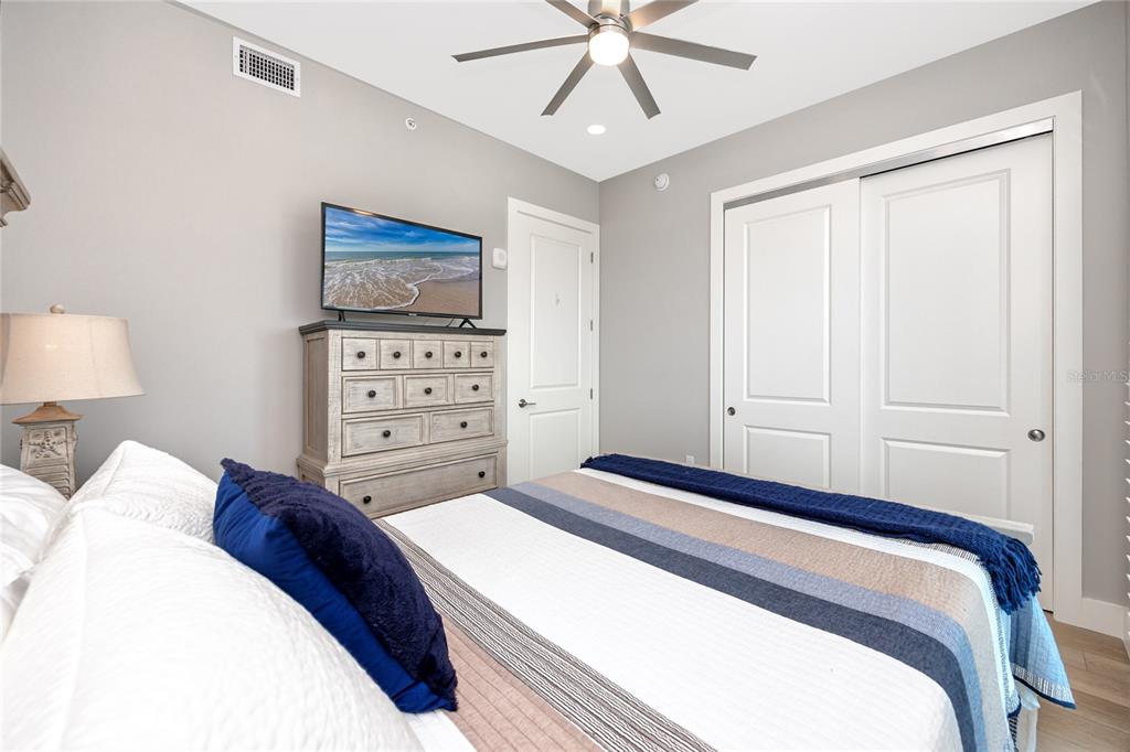 300 150th Avenue, Unit 502 Madeira Beach, FL 33708 - Photo 39 of 52 a bedroom with a bed and a lamp on the dresser