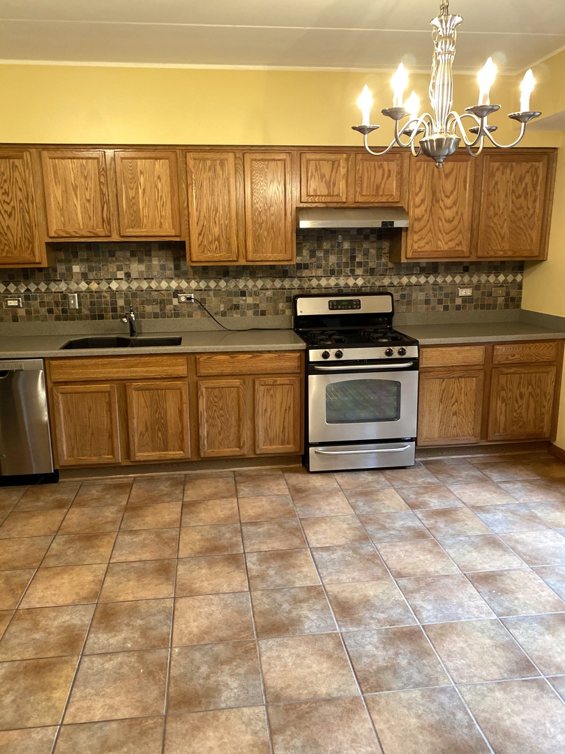 2321 183rd Street, Unit 101 Homewood, IL 60430 - Photo 13 of 27 a kitchen with stainless steel appliances granite countertop a stove a sink and a microwave