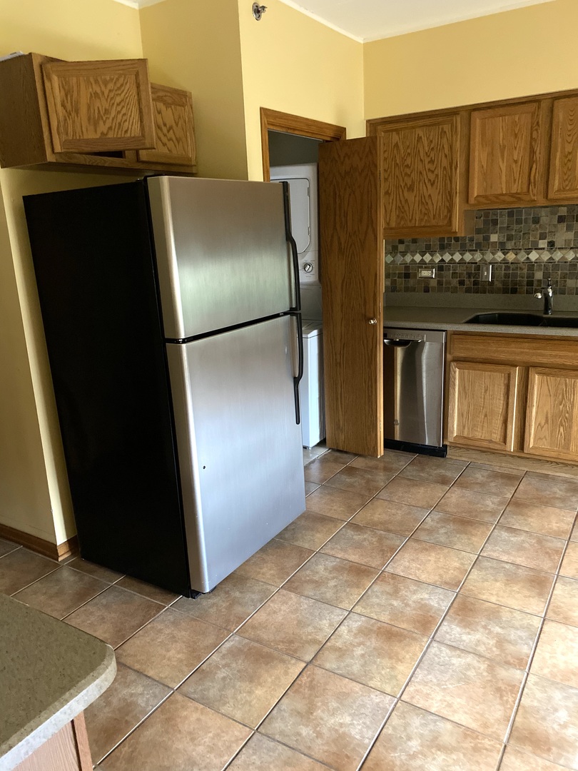2321 183rd Street, Unit 101 Homewood, IL 60430 - Photo 14 of 27 a view of a refrigerator in kitchen and an empty room