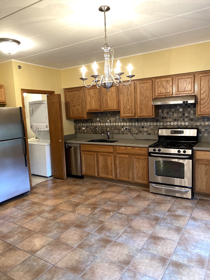 2321 183rd Street, Unit 101 Homewood, IL 60430 - Photo 16 of 27 a kitchen with stainless steel appliances granite countertop a stove a sink and a refrigerator