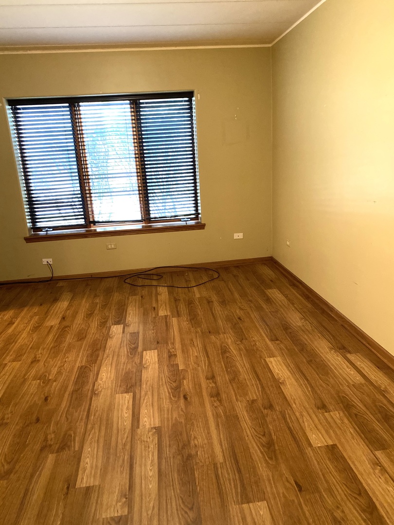 2321 183rd Street, Unit 101 Homewood, IL 60430 - Photo 18 of 27 a view of an empty room with wooden floor and a window