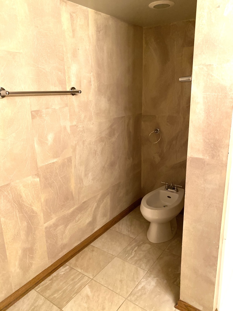 2321 183rd Street, Unit 101 Homewood, IL 60430 - Photo 22 of 27 a white toilet sitting next to a shower curtain