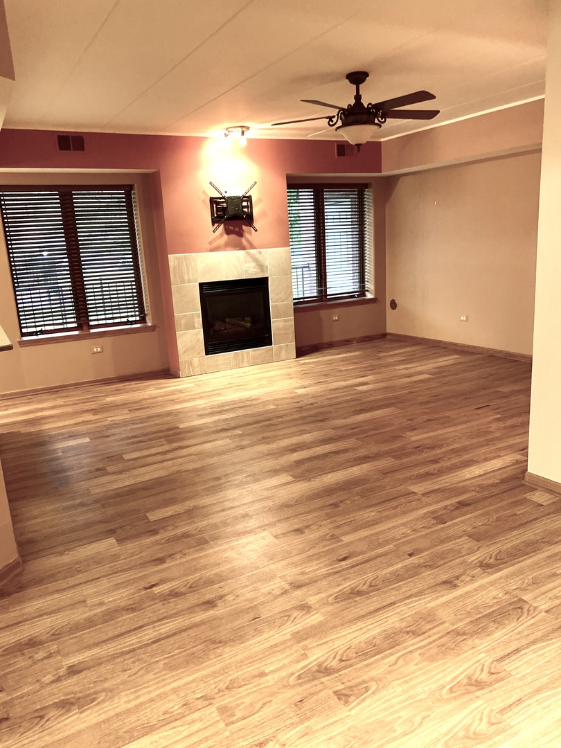 2321 183rd Street, Unit 101 Homewood, IL 60430 - Photo 4 of 27 a view of a livingroom with a fireplace a ceiling fan and wooden floor