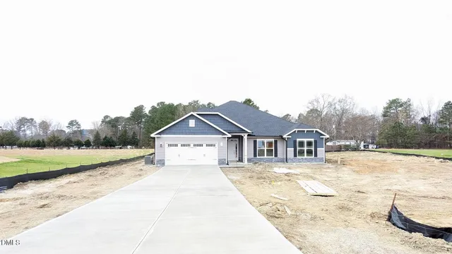 a front view of a house with a yard and trees