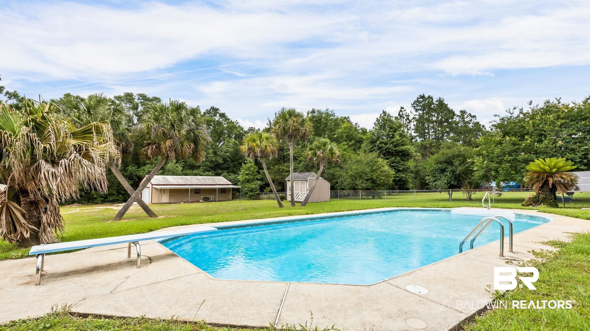 15096 Highland Circle Foley, AL 36535 - Photo 50 of 52 Outdoor swimming pool with integrated steps and a diving board, surrounded by a concrete patio