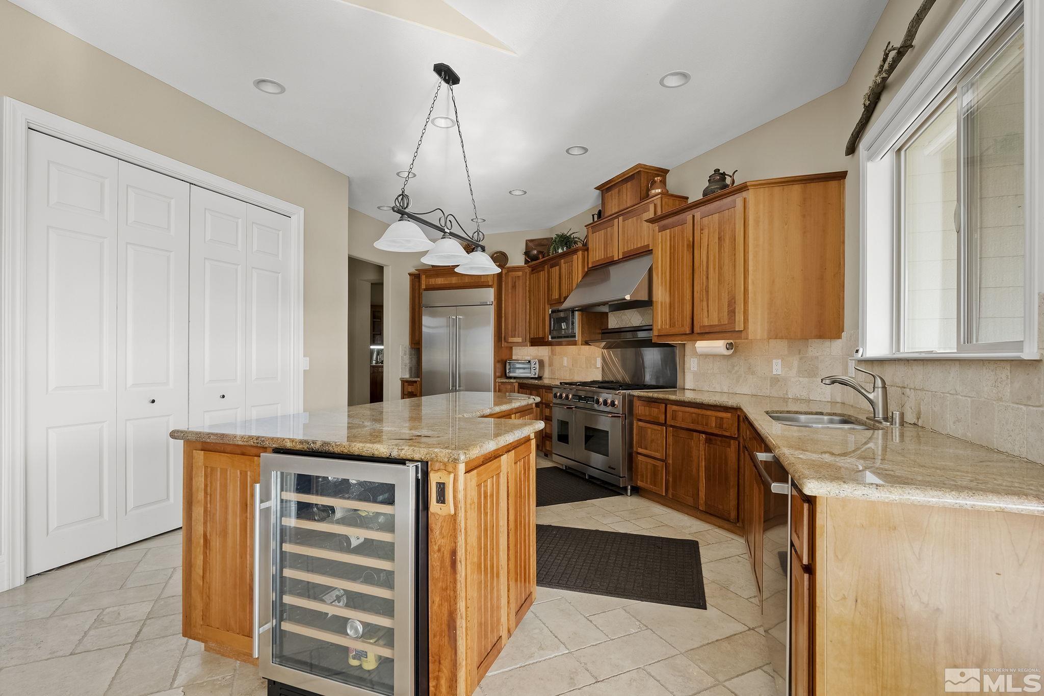 2425 Genoa Meadows Circle Genoa, NV 89411 - Photo 17 of 40 a kitchen with granite countertop a sink stainless steel appliances and cabinets