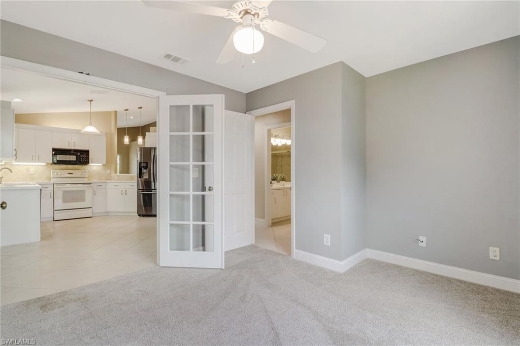 3765 Fieldstone Boulevard, Unit 1304 Naples, FL 34109 - Photo 14 of 33 an empty room with a kitchen and stainless steel appliances