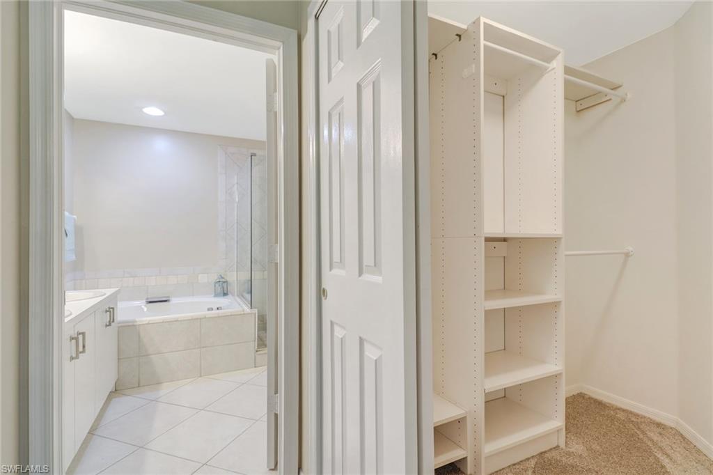 3765 Fieldstone Boulevard, Unit 1304 Naples, FL 34109 - Photo 21 of 33 a bathroom with a bathtub and a shower