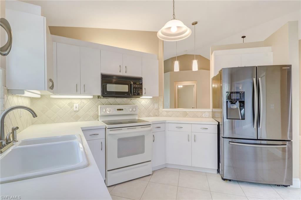 3765 Fieldstone Boulevard, Unit 1304 Naples, FL 34109 - Photo 10 of 33 a kitchen with cabinets stainless steel appliances and a counter space