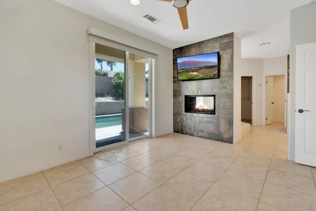 an empty room with windows and fireplace