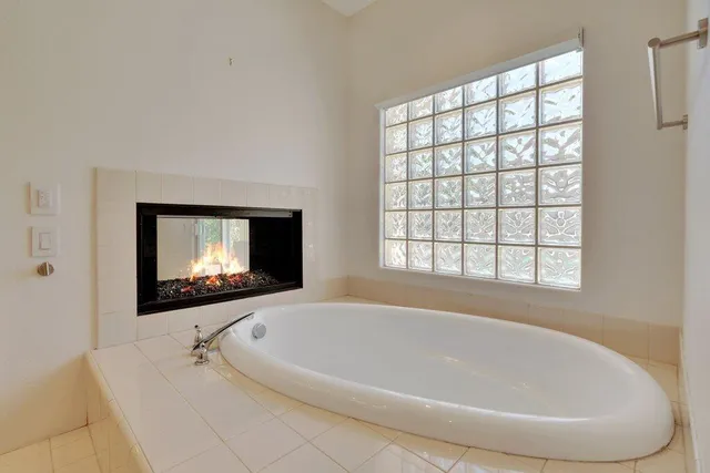 a white bath tub sitting in a bathroom next to a window