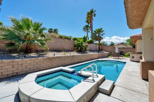 a view of swimming pool with outdoor seating and plants
