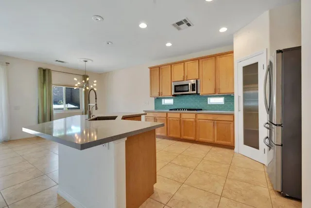 a kitchen with stainless steel appliances granite countertop a sink and a refrigerator