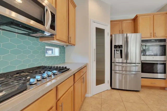 a kitchen with stainless steel appliances granite countertop a stove and a refrigerator