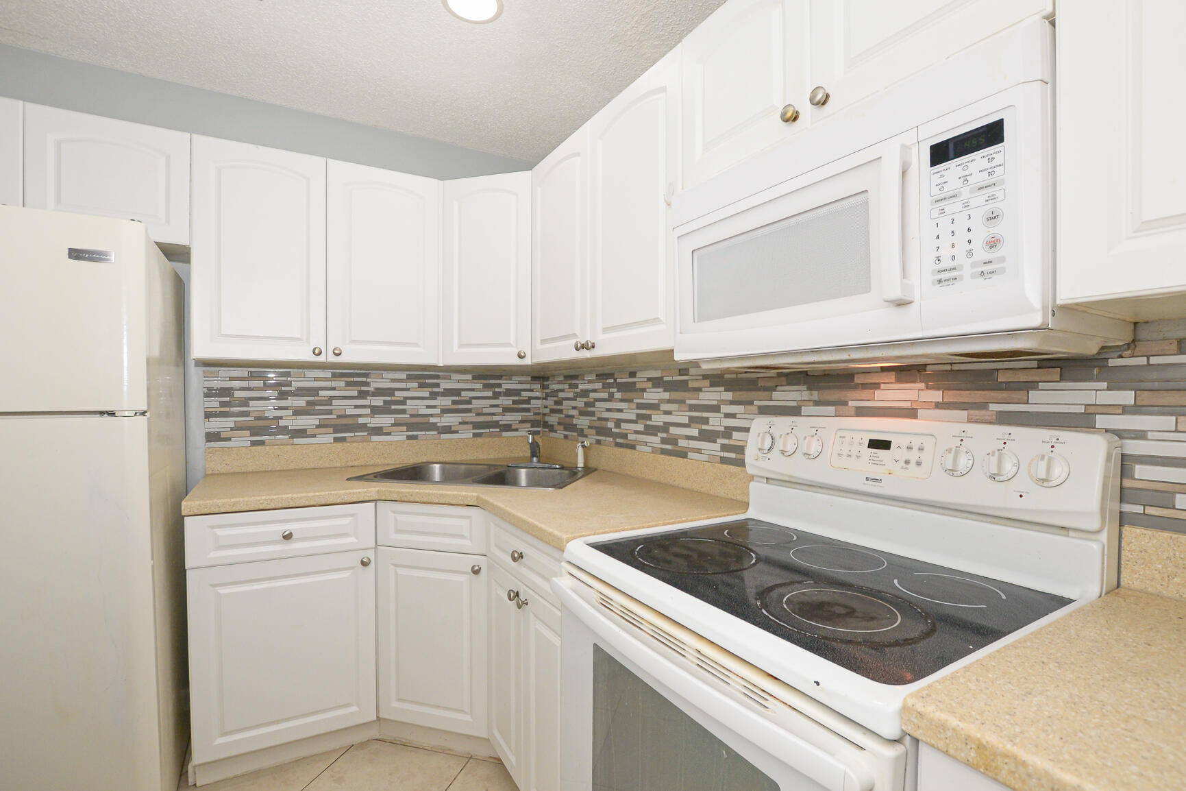 2007 Oleander Boulevard, Unit B Fort Pierce, FL 34950 - Photo 11 of 21 a kitchen with granite countertop white cabinets and white appliances