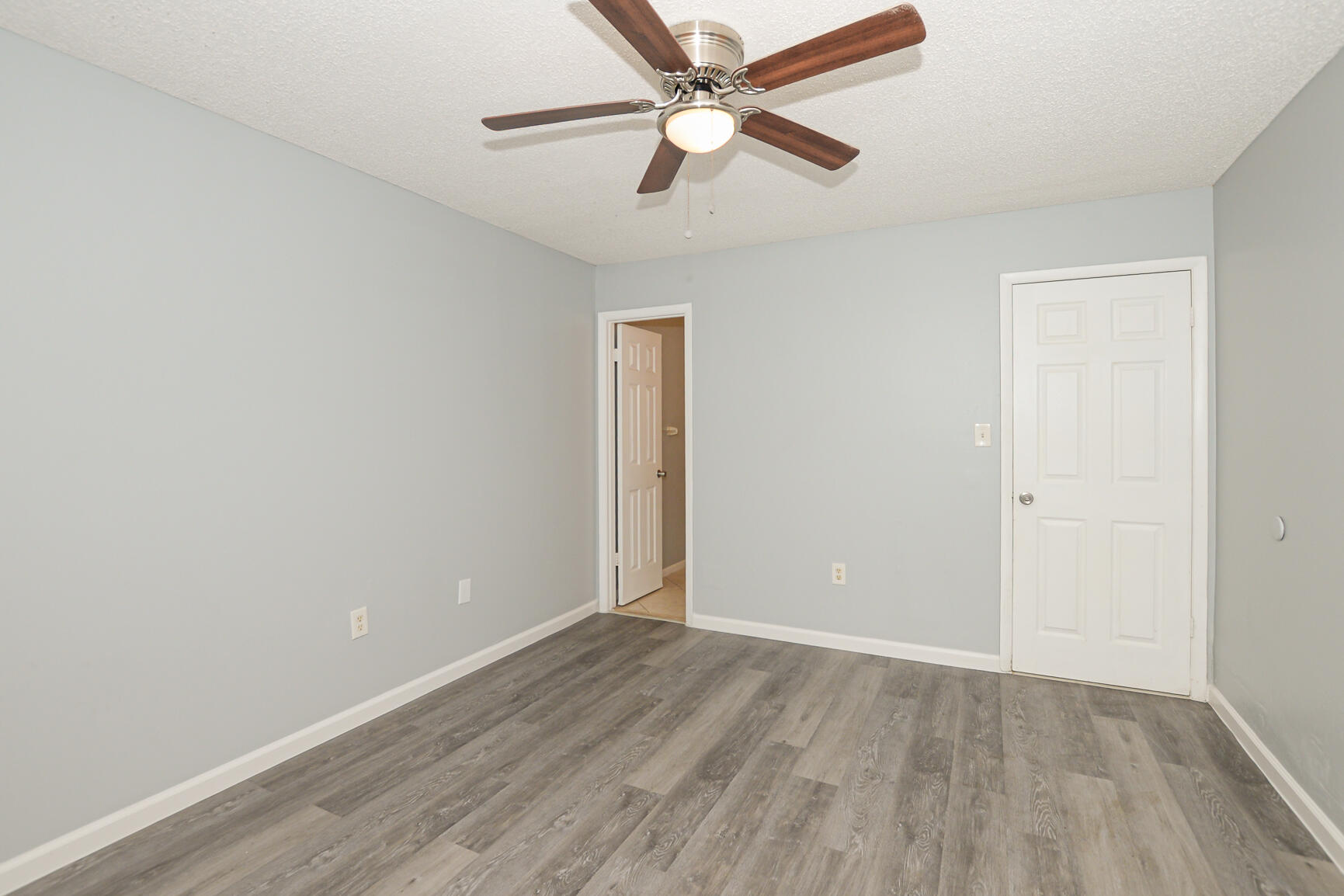 2007 Oleander Boulevard, Unit B Fort Pierce, FL 34950 - Photo 17 of 21 an empty room with wooden floor ceiling fan and a ceiling fan