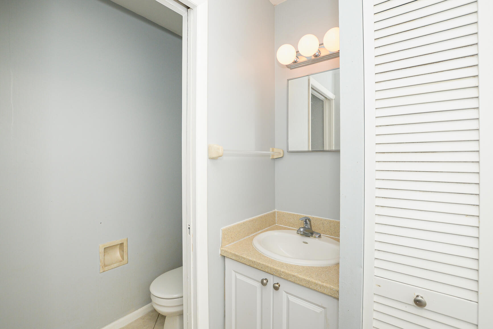 2007 Oleander Boulevard, Unit B Fort Pierce, FL 34950 - Photo 8 of 21 a bathroom with a sink a toilet and a mirror