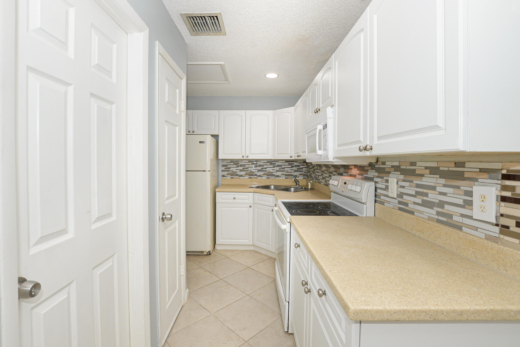 2007 Oleander Boulevard, Unit B Fort Pierce, FL 34950 - Photo 10 of 21 a kitchen with cabinets and white appliances