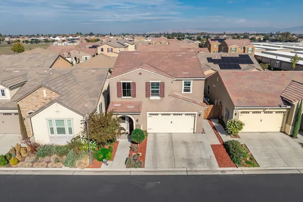 an aerial view of a house with a yard and lake view