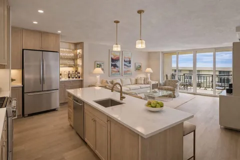 a kitchen with a sink a counter and chairs