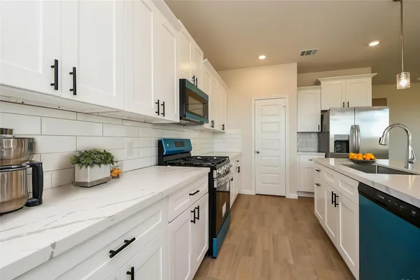 a kitchen with a dining table chairs and refrigerator
