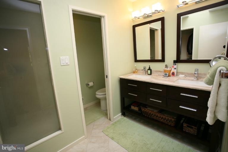 10927 Lawyers Road Reston, VA 20191 - Photo 24 of 30 a bathroom with a double vanity sink a mirror and a toilet