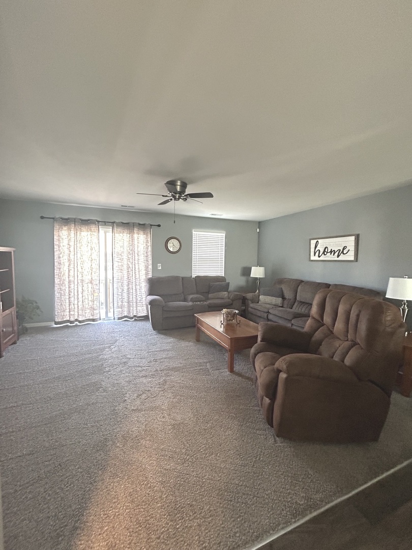 582 Spring Leaf Drive Joliet, IL 60431 - Photo 4 of 25 a living room with couches and a large window with kitchen view