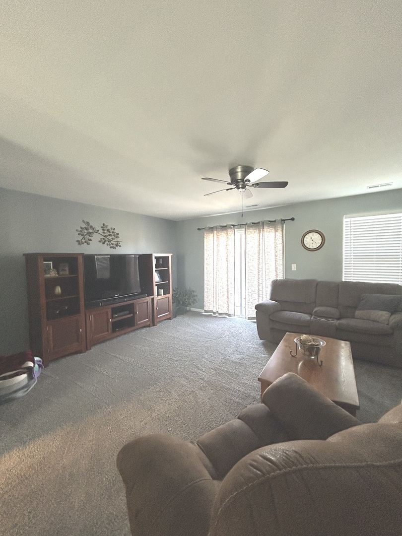 582 Spring Leaf Drive Joliet, IL 60431 - Photo 5 of 25 a living room with furniture and a flat screen tv
