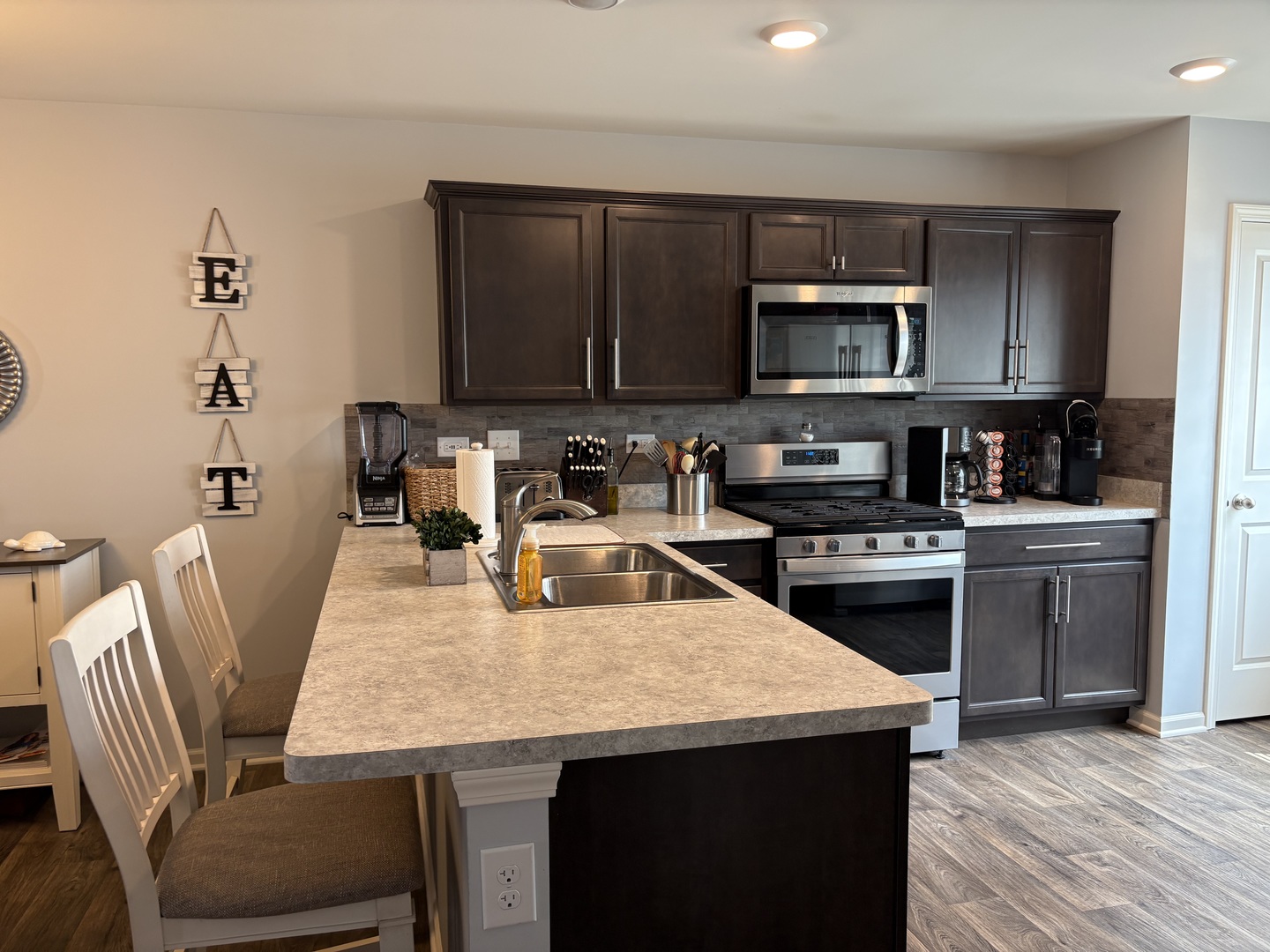 582 Spring Leaf Drive Joliet, IL 60431 - Photo 7 of 25 a kitchen with a stove a sink a microwave a dining table and chairs