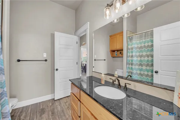 a bathroom with a granite countertop sink mirror and a shower