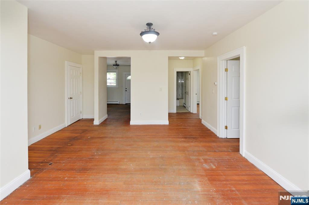 62 Broadway, Unit 1 Hackensack, NJ 07601 - Photo 6 of 25 a view of an empty room with wooden floor and a ceiling fan