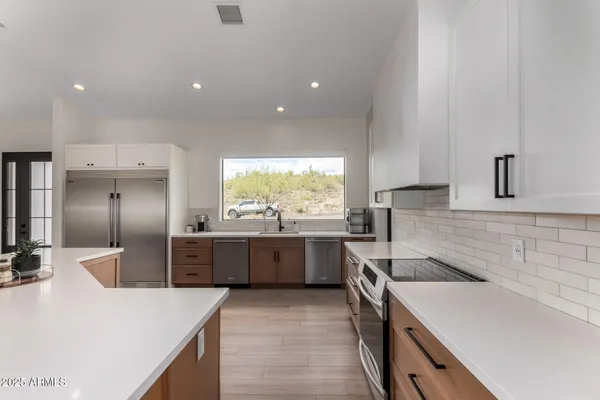 a kitchen with stainless steel appliances granite countertop a sink and a stove