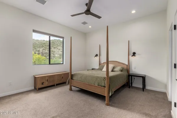 a spacious bedroom with a bed and a dresser