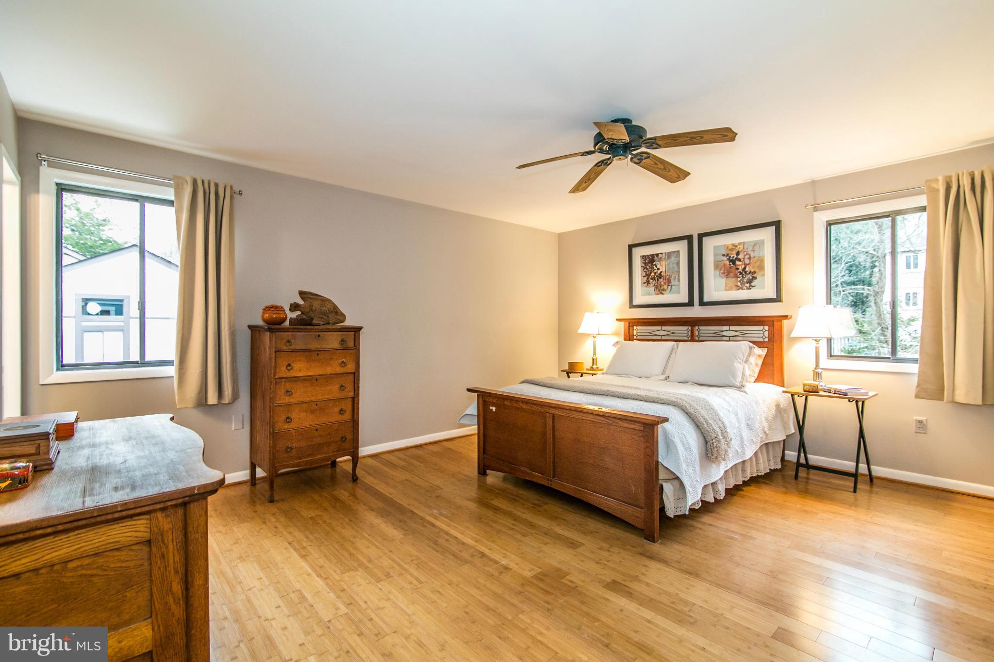 11821 Blue Spruce Road Reston, VA 20191 - Photo 14 of 28 a bedroom with a bed and dresser with wooden floor