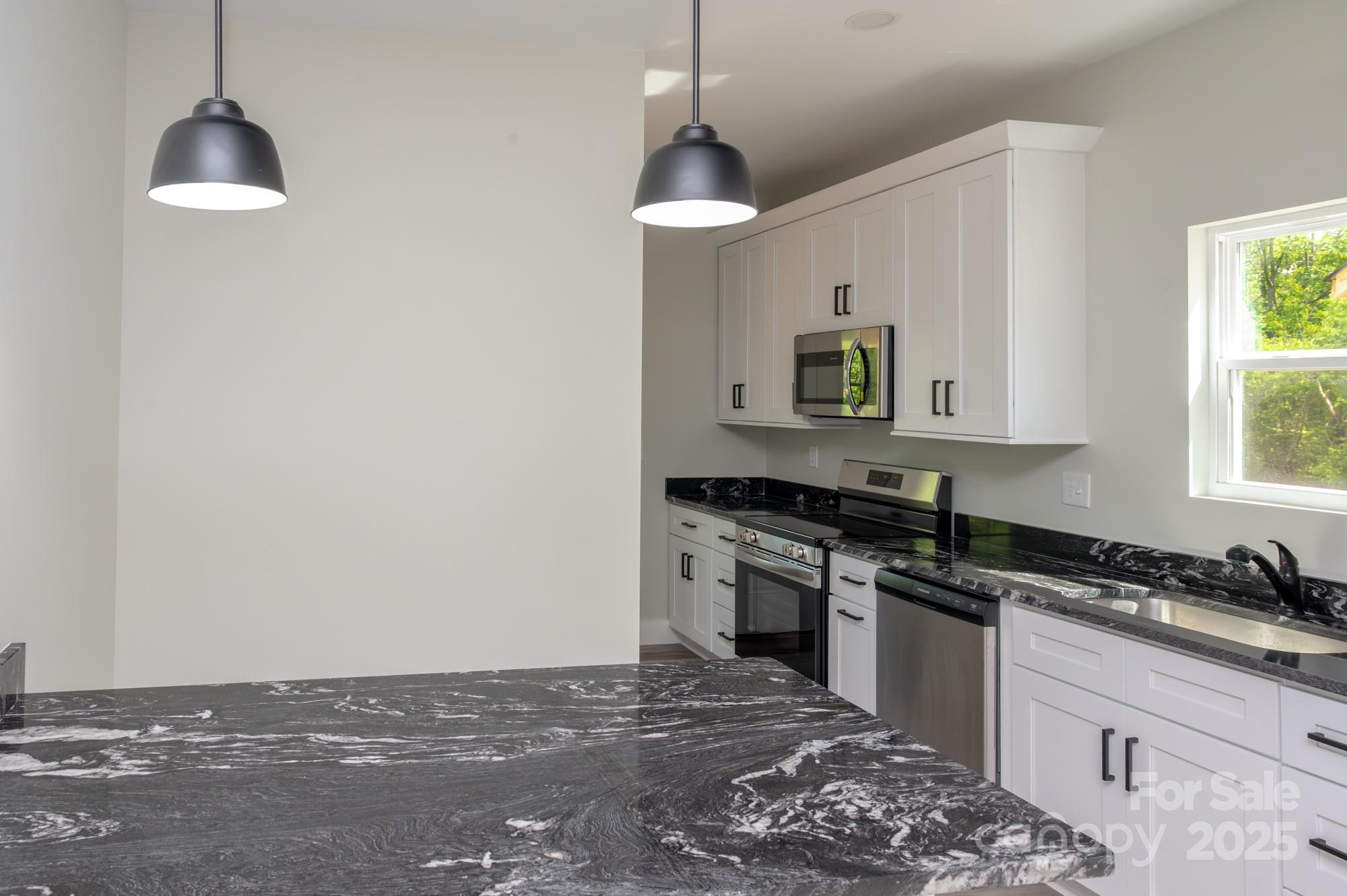 43 Robbins Circle Lexington, NC 27292 - Photo 5 of 28 a kitchen with granite countertop a stove and a sink