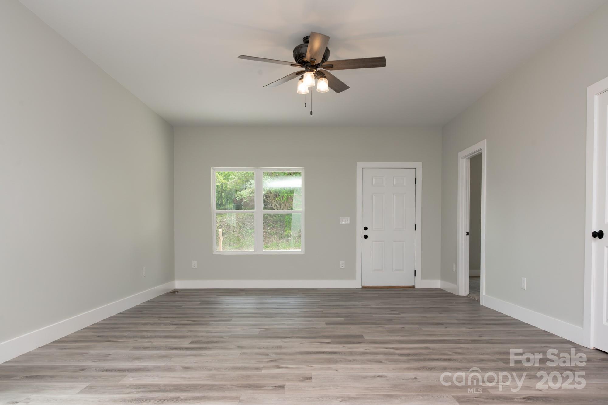 43 Robbins Circle Lexington, NC 27292 - Photo 10 of 28 an empty room with wooden floor chandelier fan and windows