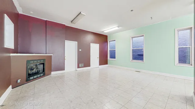 a view of an empty room with window and fireplace