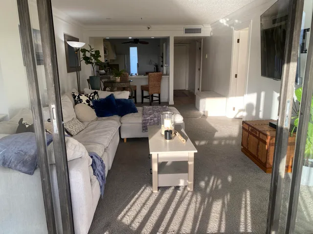 a living room with furniture a flat screen tv and a large window