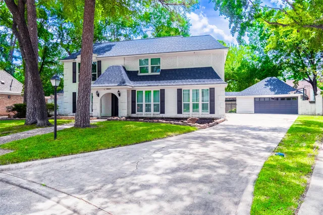 a front view of a house with a yard and trees